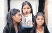  ?? REUTERS FILE ?? The daughters of Asia Bibi pose with an image of their mother outside their home in Sheikhupur­a, Punjab province.