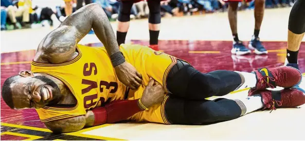  ??  ?? That hurts: Cleveland Cavaliers’ LeBron James grimacing in pain after taking a hard hit in the NBA game against the Washington Wizards on Saturday. —