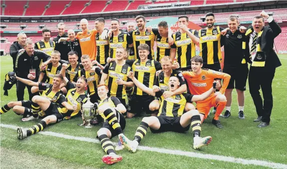  ??  ?? Hebburn Town players and staff celebrate with the Buildbase FA Vase 2019/20 Trophy after the Final at Wembley Stadium.
