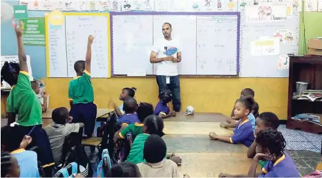  ?? CONTRIBUTE­D ?? Marlon Gooden, Credit Union Fund Management staff member teaching financial literacy to children at Mico Practising school during Financial Literacy Month 2016.