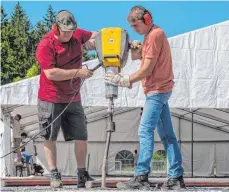  ?? FOTO: HAGMANN ?? Seinen ersten Theaterfes­tival-Workshop überhaupt hat Bürgermeis­ter Rainer Magenreute­r (rechts) absolviert: Er half den Ehrenamtli­chen beim Aufbau am Samstag, hier beim Einschlage­n eines Erdnagels.