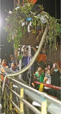  ?? DITE SURENDRA/JAWAPOS ?? ULAR PUN TERGARUK: Alat berat pembersih kotoran di Kali Buntung menggaruk seekor ular sanca Selasa malam. Ular itu menjadi tontonan warga dan relawan bersih-bersih kali.