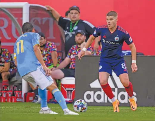  ?? CHICAGO FIRE FC ?? The Fire’s Chris Mueller works against a Union defender during an MLS game Wednesday at Soldier Field. Mueller helped set up the Fire’s goal.