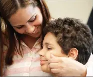  ?? AP PHOTO BY CHARLES REX ARBOGAST ?? Lidia Karine Souza smiles and pinches the cheek of her son Diogo at the Mayer Brown law firm during a news conference shortly after Diogo was reunited with his mother Thursday, June 28 in Chicago.