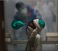  ??  ?? A health worker takes a nasal swab of a person for a Covid-19 test at a hospital in New Delhi, India