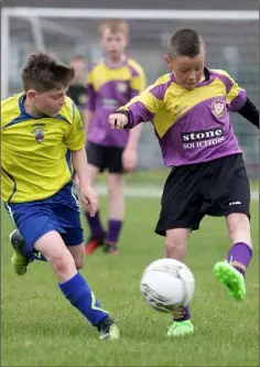  ??  ?? Jamie Lyng (New Ross Town) watches Callum Farrell (Wexford Albion) launching an attack for the home team.