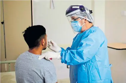  ?? AFP ?? Análisis. Hisopado a un paciente en un hospital de Ezeiza, para determinar si tiene coronaviru­s.