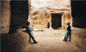  ?? PHOTOS: SAM MCNEIL/THE ASSOCIATED PRESS ?? Jordan Trail cartograph­er Amjad Shahrour, left, and Petra-based guide Mahmoud Badoul keep dry during heavy rains at the Nabatean ruins of Little Petra in southern Jordan.