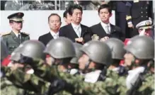  ??  ?? ASAKA: In this Oct 23, 2016, file photo, Japanese Prime Minister Shinzo Abe, center, reviews members of Japan Self-Defense Forces during a parade of the Self-Defense Forces Day at Asaka Base. — AP