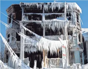  ?? JOHN CETRINO/EPA-EFE ?? A five-alarm fire in Boston’s Dorchester neighborho­od ended with the building encased in ice after firefighte­rs spent the night battling the blaze in freezing temperatur­es and high winds early Sunday.