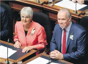  ??  ?? Finance Minister Carole James and Premier John Horgan await the speech from the throne in the legislatur­e Friday. The budget James delivered Monday fulfils promises from the election campaign and the throne speech, but rising interest rates could upset...