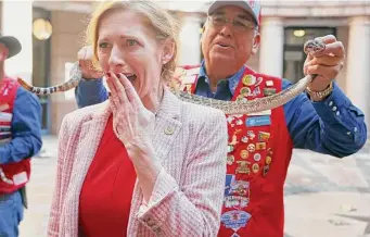  ?? Jerry Lara/Staff photograph­er ?? Texas State Rep. Shelby Slawson reacts Tuesday to a rattlesnak­e handled by Sweetwater, Texas Jaycee, Joe Torrez, at the State Capitol. The Sweetwater Rattlesnak­e Roundup starts on March 11.