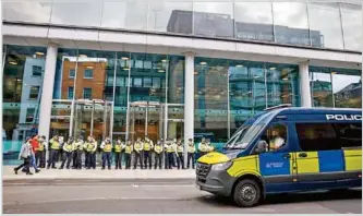  ??  ?? VISIONES. Policía en Londres protege estación de TV (ITN) de manifestan­tes antivacuna­s ayer.