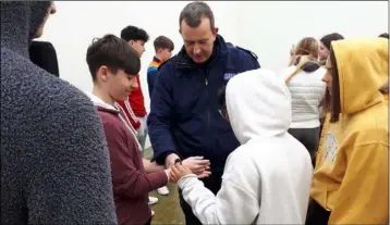  ??  ?? Daria Marinskait­e, Alex Szwarc, Aneena Juddymon Pynadath, Kyle Sinnott and Aaron Quigley sampling some handcuffs with Sergeant Brendan Costello.