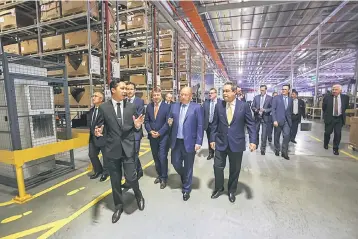  ??  ?? BMW Group Parts Distributi­on Centre Malaysia manager Rizal Abu Bakar (left) leading the tour around the facility of the New BMW Group Regional Parts Distributi­on Centre, Senai yesterday.