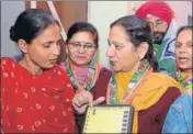  ?? PARDEEP PANDIT/HT ?? Congress candidate Jasleen Kaur Sethi showing her party symbol on a dummy EVM to a voter during a doortodoor campaign in Jalandhar on Thursday.