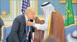  ??  ?? Saudi King Salman presents Donald Trump with the Order of Abdulaziz alSaud medal, the kingdom’s top civilian honour, at the Saudi Royal Court in Riyadh on Saturday.