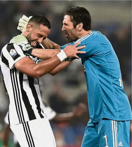  ?? — AFP ?? Juventus’ veteran goalkeeper Gianluigi Buffon (right) celebrates with defender Medhi Benatia after beating AC Milan 4- 0 to win the Italian Cup on Wednesday.