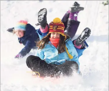  ?? Tyler Sizemore / Hearst Connecticu­t Media ?? Old Greenwich’s Caitlin Ungari, 10, sleds with her friend Dorothea Kloster, also 10, at Innis Arden Golf Club in Old Greenwich on Thursday.