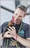  ?? DaJuan Bennett ?? VOLUNTEER Andrew Brown holds a rooster at the East Valley shelter in Van Nuys.