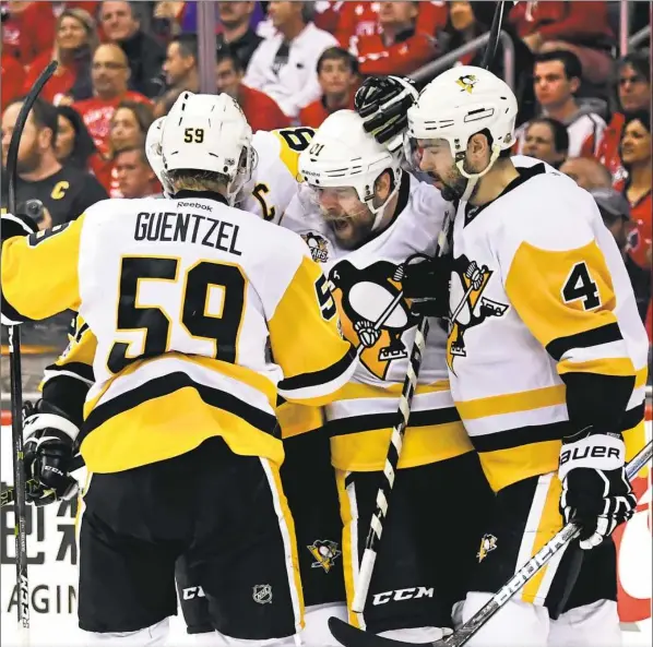  ?? Peter Diana/Post-Gazette ?? Phil Kessel is mobbed after scoring his second goal of Game 2 Saturday night in Washington. The goal gave the Penguins a 4-1 lead early in the third period — a lead they rode to a 2-0 series advantage as this series shifts to PPG Paints Arena Monday. More on Kessel, Page C-3.