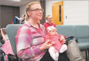  ??  ?? Jessica Magorian of King George, Va., watches a baby wearing demonstrat­ion, learning different carrying techniques to try with her 12-week-old daughter, Savannah.