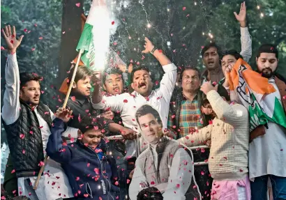  ?? PTI ?? Party workers display Congress president Rahul Gandhi’s cutout as they celebrate after initial trends showed the party leading in the state Assembly election results, at the Congress headquarte­rs in New Delhi on Tuesday. —