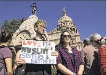  ?? JAY JANNER / AMERICAN-STATESMAN ?? Jonathan Krugman (left) and Alexandra Castello helped form a human chain around Muslim attendees Jan. 31 during the Muslim Day rally at the Capitol.