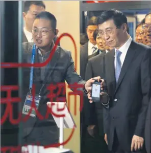  ?? ZHU XINGXIN / CHINA DAILY ?? Wang Huning, a member of the Standing Committee of the CPC Central Committee Political Bureau, visits a self-service supermarke­t during the 4th World Internet Conference in Wuzhen, Zhejiang province, on Sunday.