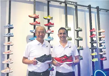  ??  ?? Mr Hirota (left) and Mr Gandhi display Asics running shoes. The Japanese brand expects Thailand will become its largest market in Asean in 3-5 years.