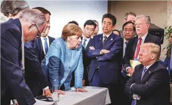  ?? Reuters ?? German Chancellor Angela Merkel speaks to US President Donald Trump as Japanese Prime Minister Shinzo Abe and French President Emmanuel Macron (third from left) look on during the second day of the G7 meeting in Charlevoix city of La Malbaie, Quebec,...