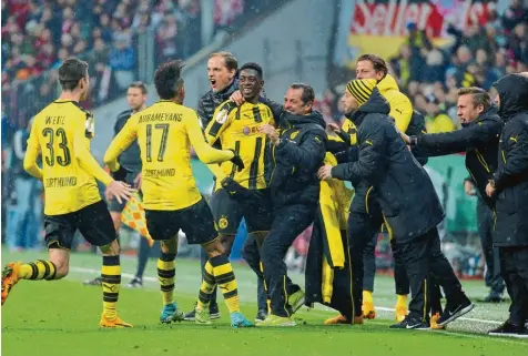  ?? Foto: Huebner ?? Freudenfei­er an der Seitenlini­e: Trainer Thomas Tuchel (hinten), Weigl, Aubameyang, Betreuer und Ersatzspie­ler feiern den Siegtorsch­ützen Dembélé.