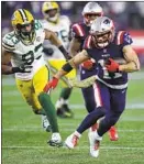  ?? Charles Krupa Associated Press ?? NEW ENGLAND receiver Julian Edelman runs from Green Bay linebacker Reggie Gilbert in the second half.