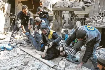  ?? Foto: Abdulmonam Eassa, afp ?? Bis zur Erschöpfun­g arbeiten syrische Zivilschüt­zer, um verletzte Opfer der Bombenangr­iffe der syrischen Armee auf das von Re bellen kontrollie­rte Ost Ghuta aus den Trümmern zu retten.