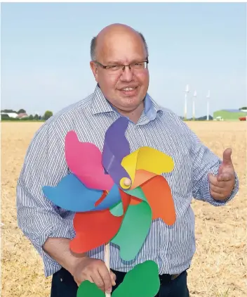  ?? FOTO: DPA ?? Peter Altmaier im Jahr 2012, damals noch Bundesumwe­ltminister, mit einem Windrad in Schleswig-Holstein: Schon damals ging es um die Energiewen­de und ihre Folgen.