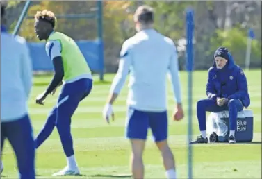  ??  ?? El entrenador alemán Thomas Tuchel, al fondo durante el entrenamie­nto del Chelsea de ayer.