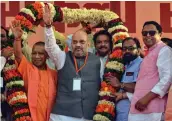  ?? — PTI ?? BJP president Amit Shah being garlanded along with Uttar Pradesh chief minister Yogi Adityanath during an election rally in Agra on Sunday.