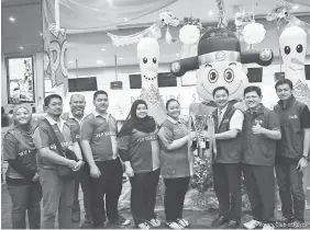  ??  ?? Rotary District 3310 Assistant Governor Leslie Phuan (third right) presenting the challenge trophy to members of the Pin Ten Cafe team while Yong (second right) and Chong (right) look on.