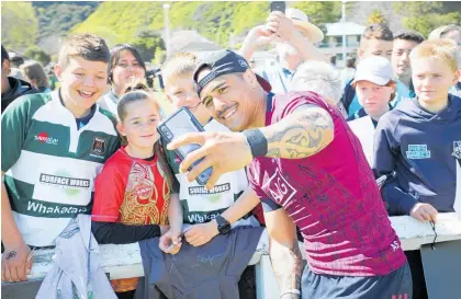  ?? Photo / Andrew Warner ?? All Blacks halfback Aaron Smith takes a selfie with some fans at Rugby Park in Whakata¯ne.