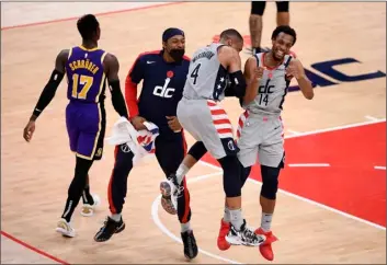  ?? AP Photo/Nick Wass ?? Washington Wizards guard Ish Smith (14) celebrates after his dunk with guard Russell Westbrook (4) and guard Bradley Beal (second from left) during the second half of an NBA basketball game as Los Angeles Lakers guard Dennis Schroder (17) walks by, on Wednesday in Washington.