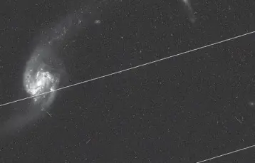  ?? NASA ?? The white streaks in this photo taken by the Hubble Space Telescope are trails of passing satellites.