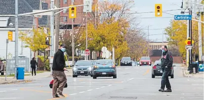  ?? JULIE JOCSAK TORSTAR ?? People wear masks while walking downtown St. Catharines on Monday — a day when the local number of COVID-19 cases, hospitaliz­ations and deaths rose. The seven-day rolling average of new cases in the region is now just under 19.