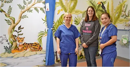  ?? ?? Nicky Halford from charity Time is Precious (centre) along with Heather White (left) and Jennifer Ocampo, both from the Theatres Recovery Team, in front of the mural in the children’s recovery room at the RUH