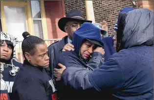  ?? NANCY STONE/CHICAGO TRIBUNE/THE ASSOCIATED PRESS Janet Cooksey, center, the mother of Quintonio LeGrier, is comforted by family and friends during a press conference in Chicago on Sunday. ??