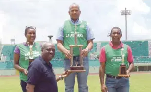  ??  ?? El presidente de la Federación Dominicana de Atletismo, Gerardo Suero, premia a Gregorio Ramírez, de La Romana, Tomasa Goméz, de San Pedro de Macorís y Mariano Cedeño, de El Seibo, como los máximos ganadores del primer, segundo y tercer lugar en el...