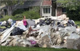  ?? JAY JANNER — AUSTIN AMERICAN-STATESMAN (VIA AP) ?? Paige Maupin walks on Contour Place after helping her brother at his flood-damaged home in the Meyerland neighborho­od in Houston after Hurricane Harvey on Friday Sept. 1, 2017.