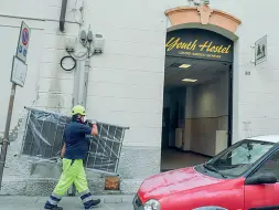  ??  ?? Al lavoro Gli operatori della Protezione civile portano i letti all’ex Ostello