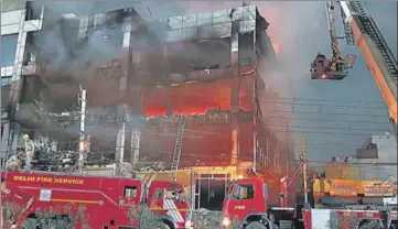  ?? HT PHOTO ?? Firefighte­rs try to douse a blaze that broke out in a building near the Mundka metro station in New Delhi on Friday.