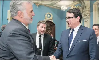  ?? JACQUES BOISSINOT/THE CANADIAN PRESS ?? Quebec Premier Philippe Couillard greets Opposition Leader Pierre Karl Péladeau as he enters the legislatur­e for question period on Tuesday in Quebec City.