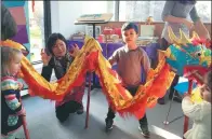  ??  ?? Children try out the dragon dance in London at a workshop during Spring Festival hosted by Oxford-based Snowflake Books.